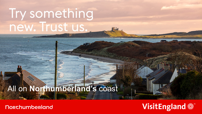 All on Northumberland's coast campaign banner showing Dunstanburgh Castle across the bay, with the tagline Try something new. Trust us.