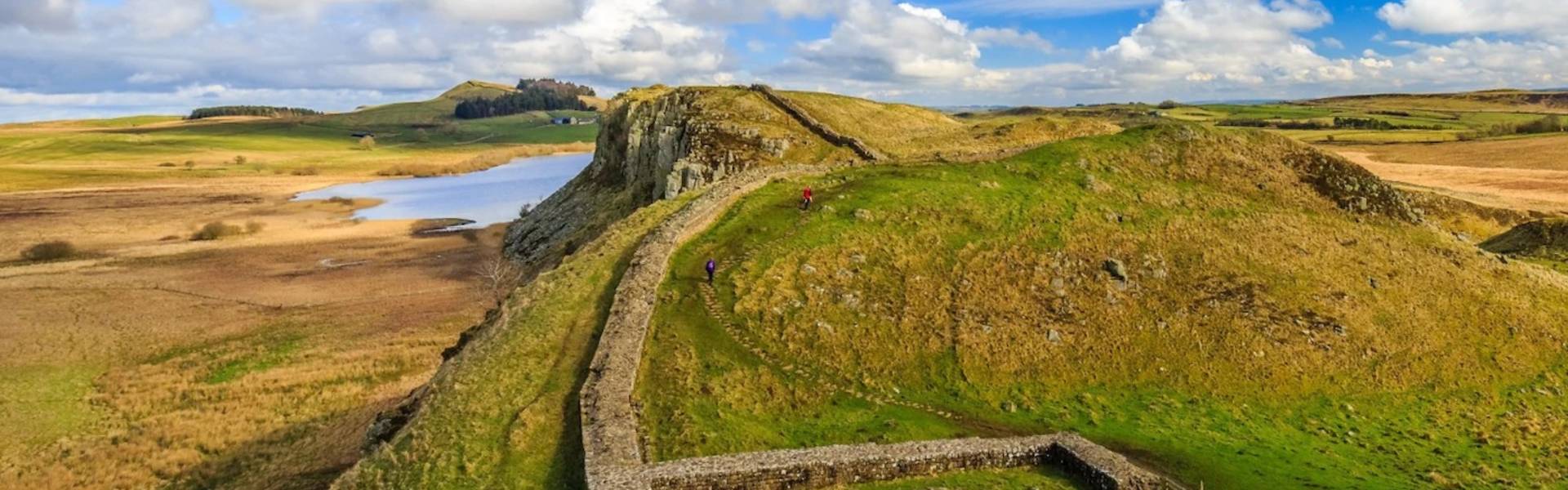 Hadrian’s Wall stretches across the Whin Sill escarpment near Crag Lough in Northumberland National Park, with rolling countryside and open skies surrounding the UNESCO World Heritage Site.