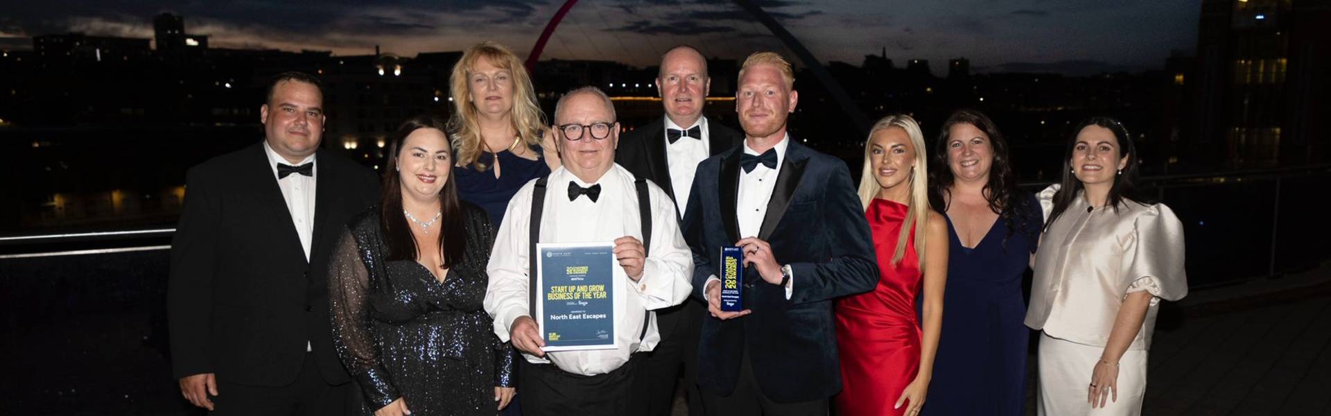 Group of award recipients and guests posing on stage at the North East Chamber of Commerce Awards, with a winner holding a Start Up and Grow Business of the Year award plaque.